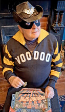 Load image into Gallery viewer, Vince Ray wearing a VooDoo sweater and cowboy hat, playing Voodoo Spin.